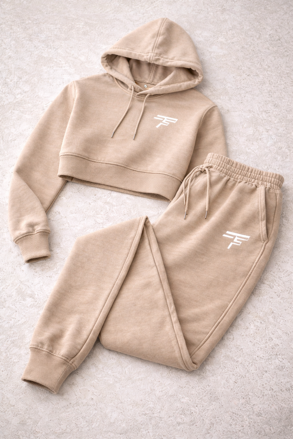 Beige hoodie and jogger set with a logo on a light gray background